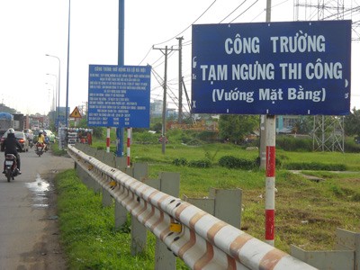 A signboard announces temporary halt of the Hanoi Highway project in Thu Duc District of HCMC (Photo: SGGP)